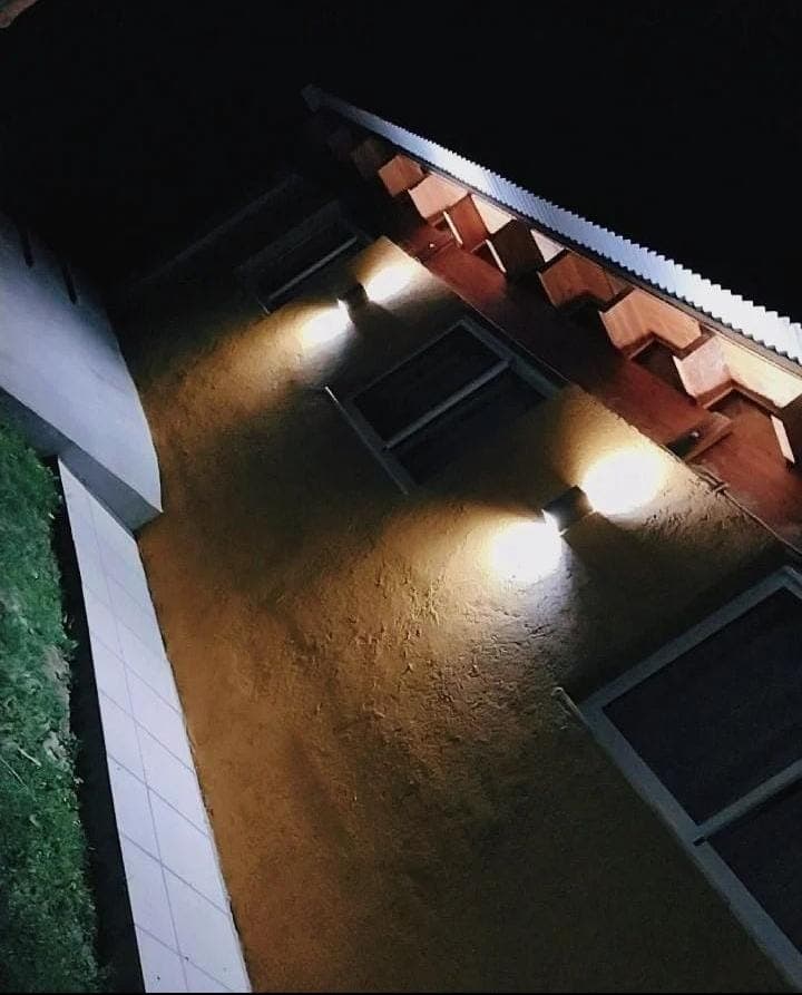 Fachada iluminada de la cabaña Lado Soleado de noche